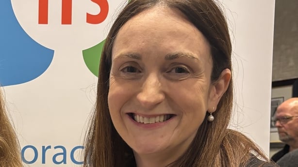 Close up image of Anne Marie McLaughlin, a woman with brown hair and brown eyes, against a white backdrop