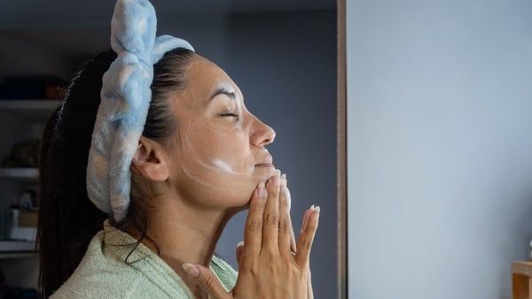 Woman applies facial cleansing foam at night