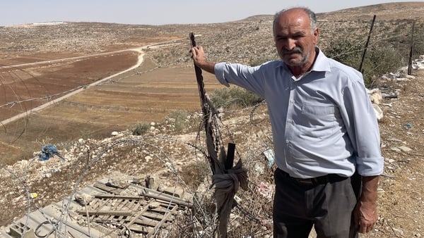 Marzouq Abu Naem, deputy secretary of the Al-Mughayyir municipality in the West Bank stands next to a plot of land