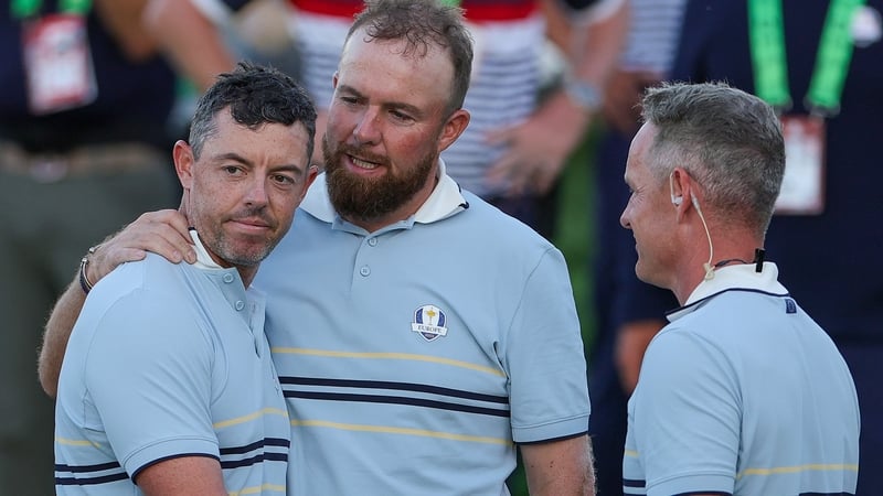 Shane Lowry hugs Rory McIlroy as they talk to captain Luke Donald at the end of the afternoon fourballs