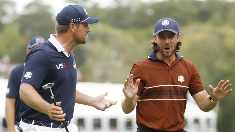 Tommy Fleetwood (R) and Bryson DeChambeau exchange words as they walk to the 16th hole
