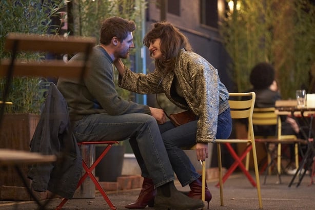 A scene from the Walsh Sisters showing a man and a woman talking outside