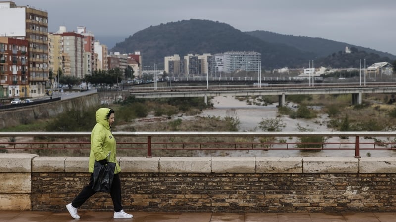 A woman crosses over the Palancia river in Sagunto during rain alerts in March this year