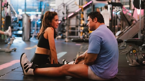 Mark Kerr (Dwayne Johnson) and Dawn Staples (Emily Blunt) talk in the gym in The Smashing Machine
