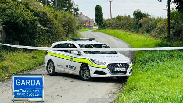 Garda car behind crime tape on closed-off road
