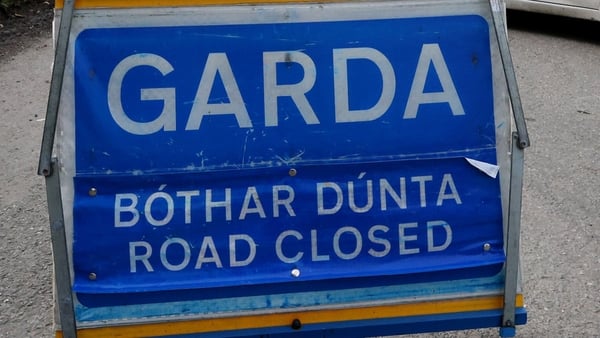 A bright blue road sign reads 'Garda Bothar Dunta Road Closed'