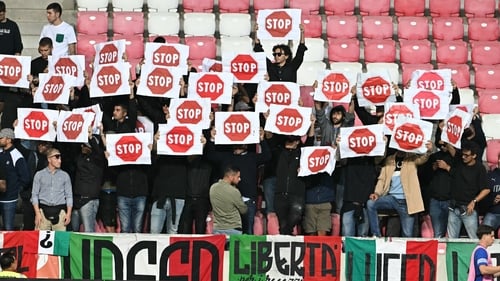 Italy fans hold signs reading 'Stop' prior to the start of the 2026 World Cup qualifier against Israel in Debrecen