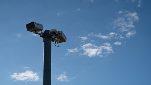 Surveillance cameras seen against blue skies