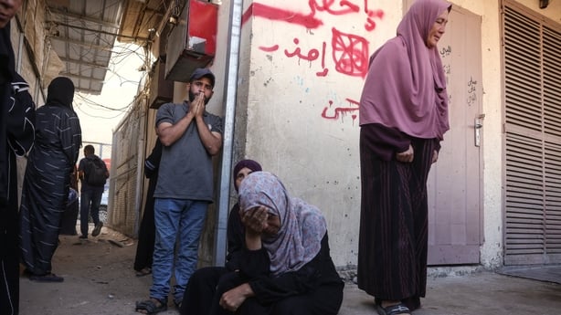 Palestinians seen mourning outside a hospital in Gaza