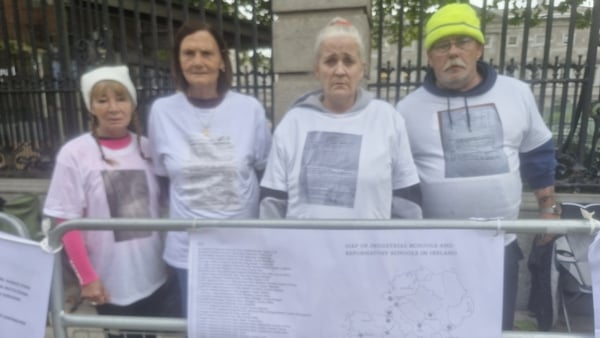 Four people stand outside the Dáil