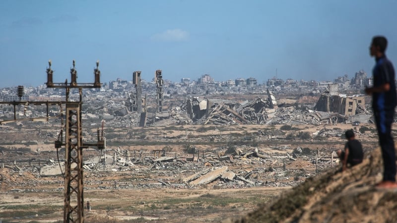 Palestinians watch smoke billowing during Israeli strikes as they are displaced southward from Wadi Gaza