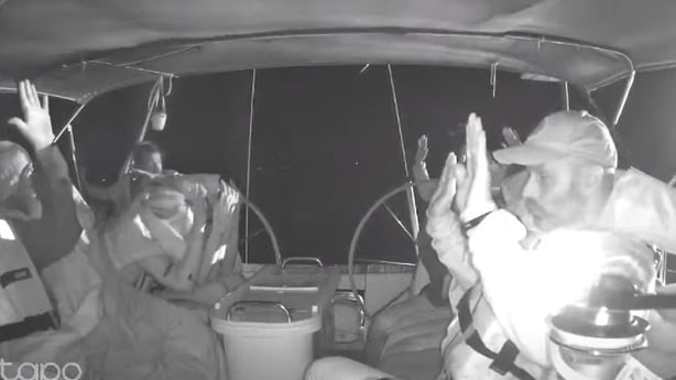 Photo shows flotilla crew members holding their hands up