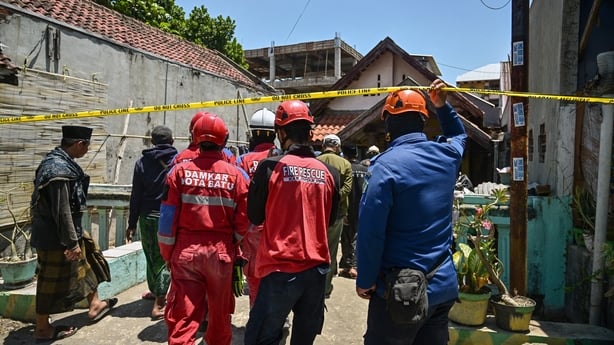 Rescuers are seen at the scene of a school collapse in Indonesia