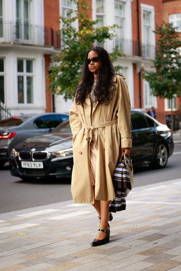 A guest wearing trench and black mary jane shoes outside Emilia Wickstead during London Fashion Week on September 21, 2025 in London, England. (Photo by Hanna Lassen/Getty Images)