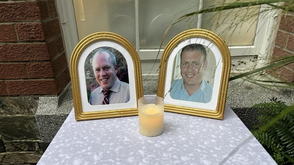 Table with framed photos of garda Tony Golden and Detective Garda Adrian Donohoe with a candle