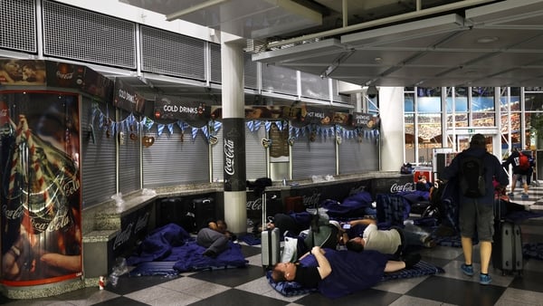 Passengers sleep on inflatable mattresses on the ground at Munich International Airport in Munich