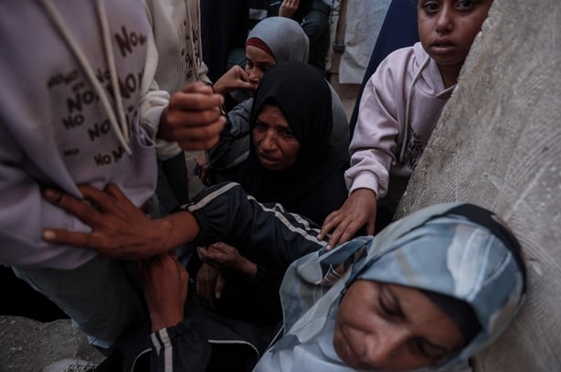 woman and children cry during a funeral in Gaza