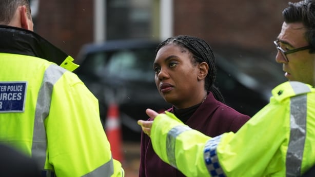 A woman talks to two british police officers
