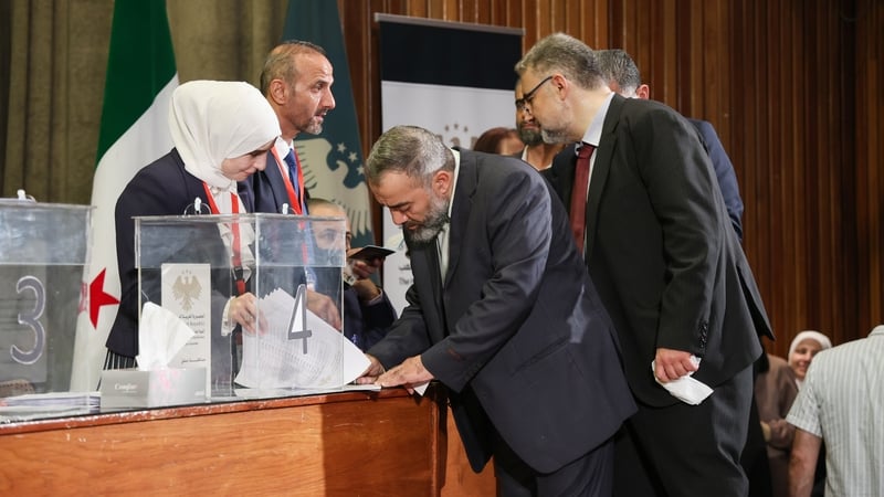 Members of electoral committees count ballots at a polling station during Syria's first parliamentary elections since the fall of Bashar al-Assad's government
