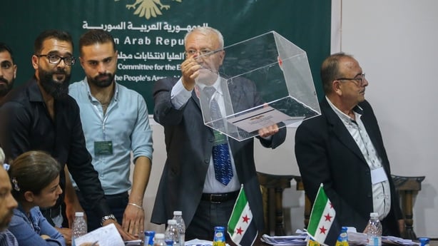 Members of the electoral body sort the votes after voting has finished inside a polling station in the government complex