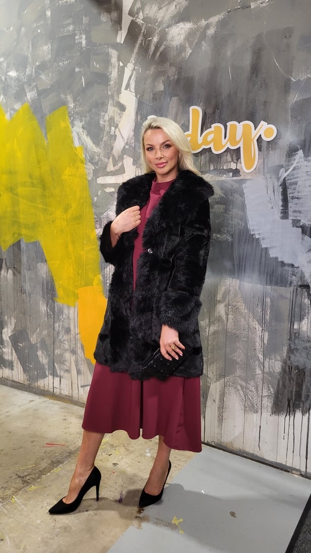 Model wearing a dress and faux fur jacket