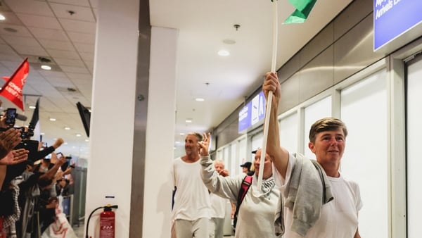 Irish participants in the Global Sumud Flotilla gesture as they are greeted in Athens airport