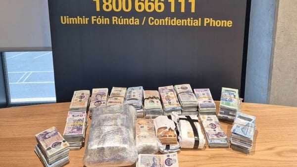 Stacks of cash on display by gardaí after seizures in Dublin and Louth