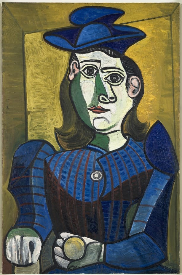 A Picasso painting of a woman wearing a blue dress and hat with a gold background.