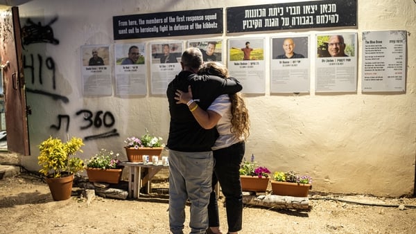 Two people embrace ahead of a memorial ceremony for the victims of the 2023 October 7 attacks at the Nova Festival grounds in Reim in southern Israel