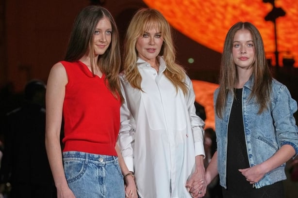 Nicole Kidman poses with her daughers in front of a large globe shaped like the sun