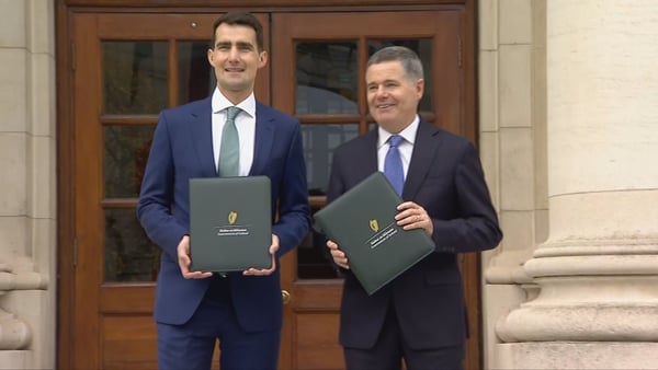 Ministers Jack Chambers and Paschal Donohoe holding folders with Budget 2026