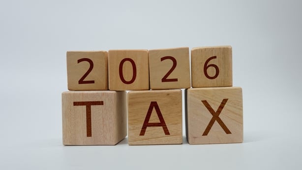 Wooden letter blocks arranged to represent the year 2026 and the word 'TAX,' emphasizing financial concepts and planning for the upcoming taxation period