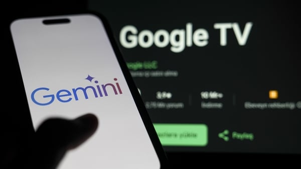 In this photo illustration logo of Google Gemini is seen on a mobile phone in front of a laptop screen displaying Google TV