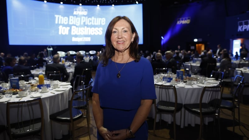 Brid O'Connell, CEO Guaranteed Irish standing in front of breakfast tables and large screen at the KPMG post budget breakfast