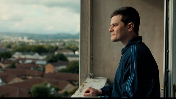 Robert Aramayo as John Davidson on the balcony of a tower block in I Swear