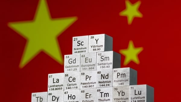 Metal cubes representing rare earth elements are stacked in front of China's flag