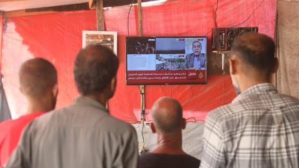 KHAN YUNIS, GAZA - OCTOBER 09: Palestinians follow the news about the cease-fire agreement that was announced and expected to take effect through television and news channels on their mobile phones in Khan Yunis, Gaza on October 09, 2025 (Photo by Abdalla