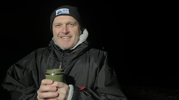 A member of Blueballs Midlands, Michael Kane, holds a flask.