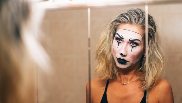 Woman with Halloween make up looking in the mirror