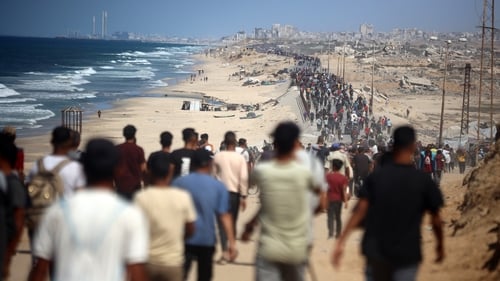 Displaced Palestinians walk along the coastal road near Wadi Gaza in the central Gaza Strip, moving towards northern Gaza