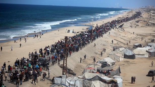 Displaced Palestinians walk along the coastal road near Wadi Gaza towards northern Gaza