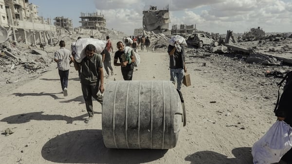 Palestinians walk along a street amid rubble in the Al-Jalaa area during a ceasefire between Israel and Hamas, under the first phase of the Gaza peace plan, in Gaza City, Gaza Strip, on October 10, 2025. (Photo by Abood Abusalama / Middle East Images via