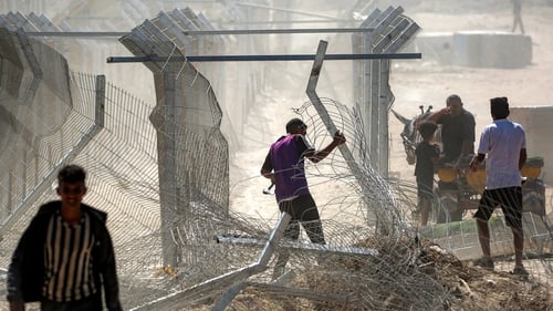 A man attempts to remove the fence and barriers at the so-called 'Netzarim corridor' near Nuseirat in central Gaza