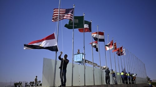 A municipal employee raises the Egyptian flag among those of other nations in Sharm el-Sheikh