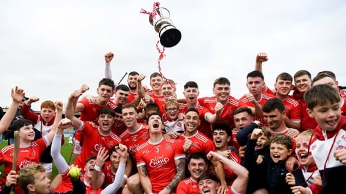 Éire Óg captain Aaron Fitzgerald celebrates with his teammates and the Jack Daly cup