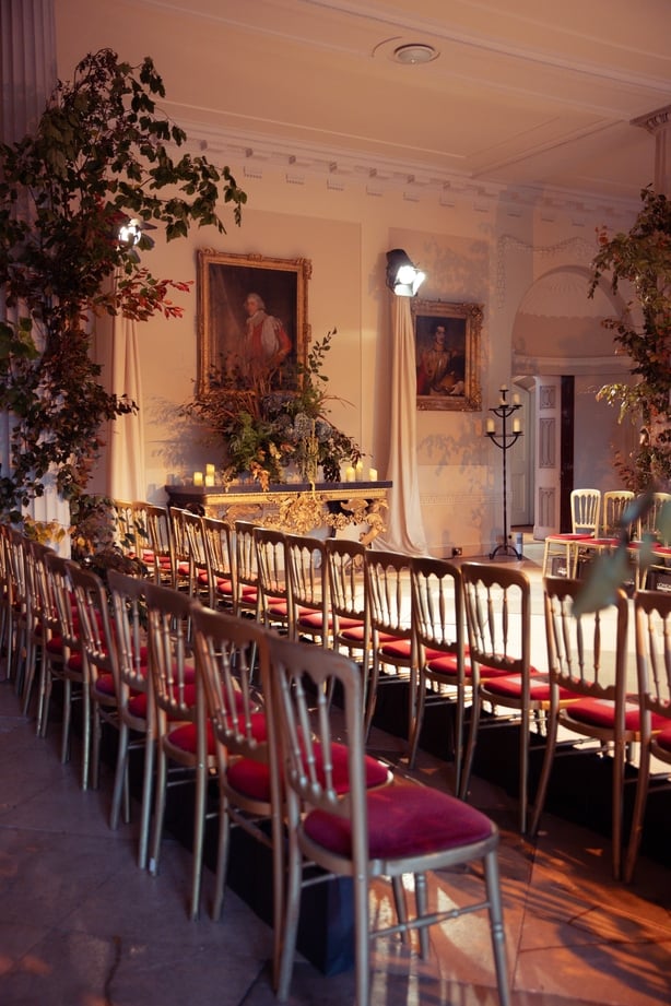 An ornate room decorated with chairs and floral arrangements