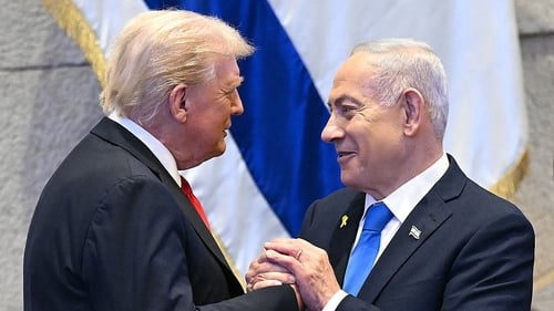 Donald Trump (L) holds hands and speaks to Israeli Prime Minister Benjamin Netanyahu at the Israeli parliament