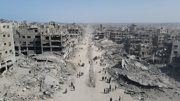 People walk amid the destruction in Gaza City in northern Gaza