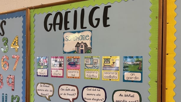 A noticeboard at a school displays work under a Gaeilge sign