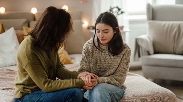 Teenage girl sharing problems with her mother in the room.